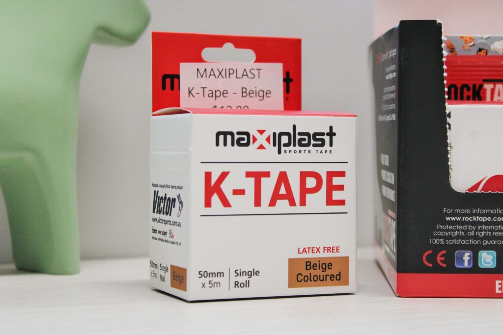 Close-up of Maxiplast K-Tape beige sports tape box, showing product details including size, color, and latex-free label.