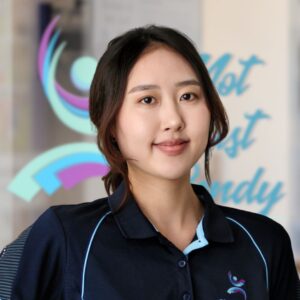 Anna, a light skinned east Asian woman with tied up dark brown hair.